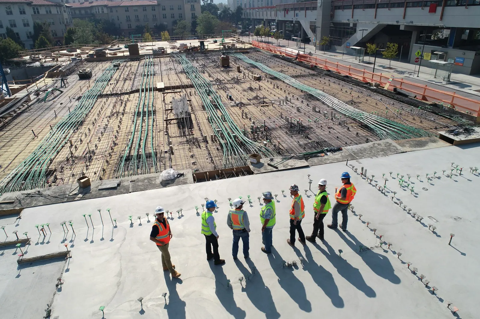 Gruppe von Beschäftigten mit Warnwesten auf einer großen Betonfläche, Symbolbild